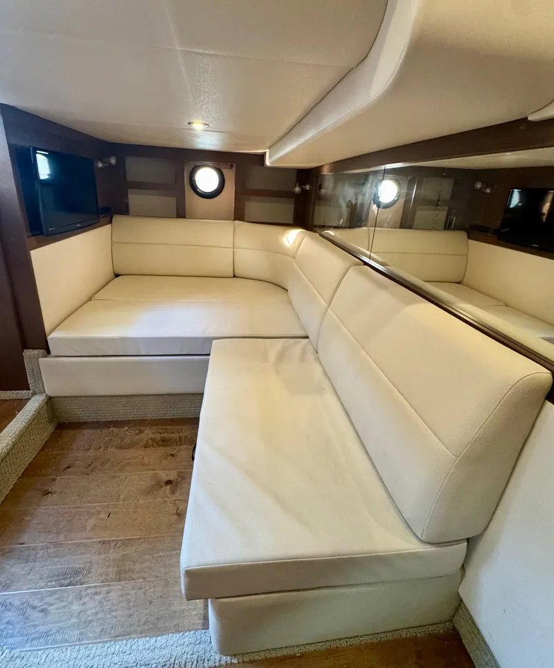 Slide: The Image of Interior of 2018 Sea Ray 350 DAC yacht with beige leather seating and wood flooring. - 32