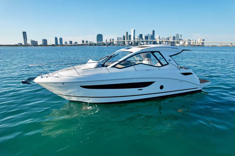 Slide: The Image of 2018 Sea Ray 350 DAC yacht on calm water with city skyline in background. - 4