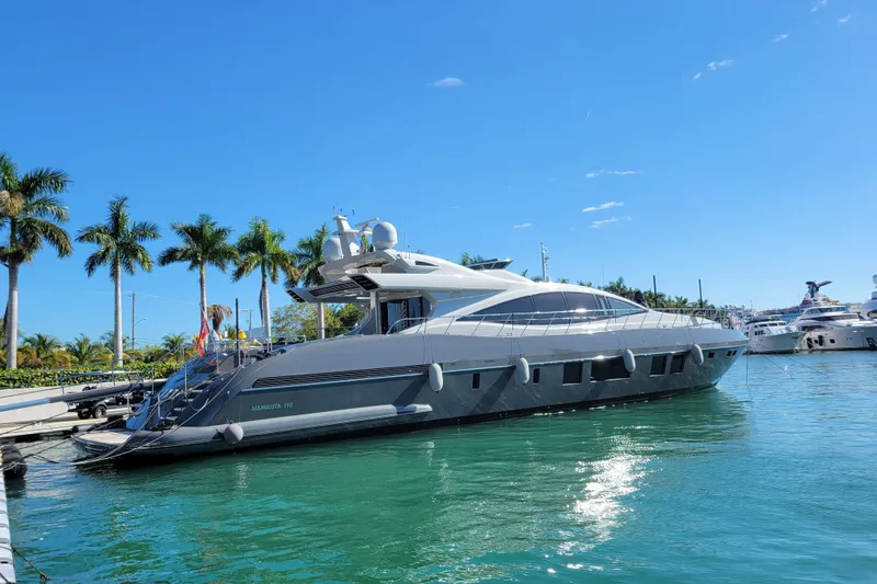 Slide: The Image of 2020 Mangusta 110 Open yacht on clear blue water under a partly cloudy sky. - 2