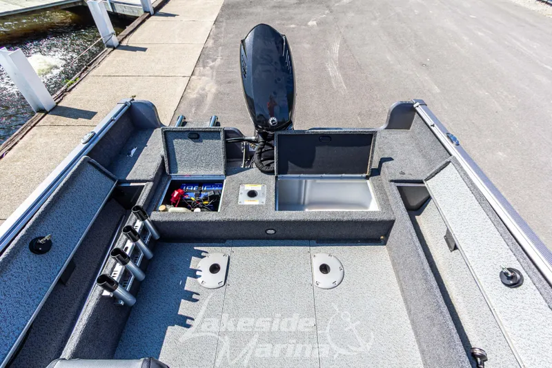 Slide: The Image of 2016 Lund 1675 Impact XS SS boat interior with storage compartments and motor. - 16