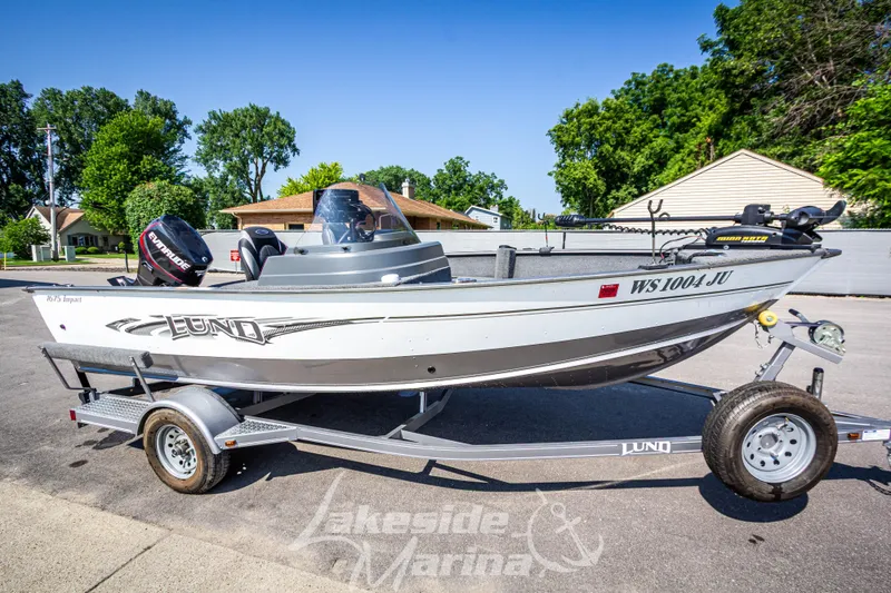 Slide: The Image of 2016 Lund 1675 Impact XS SS boat on trailer, parked outdoors. - 2
