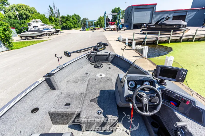 Slide: The Image of 2016 Lund 1675 Impact XS SS boat interior at a marina with navigation equipment. - 24