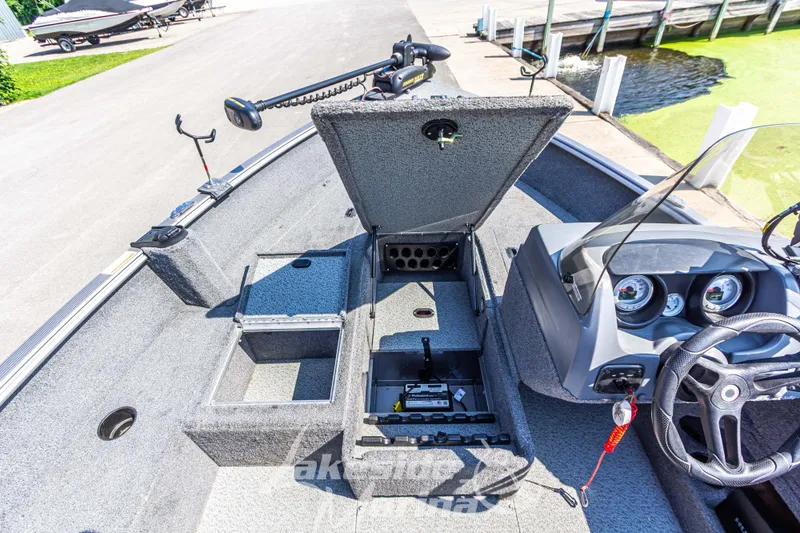 Slide: The Image of 2016 Lund 1675 Impact XS SS boat interior with open storage compartments and steering console. - 25
