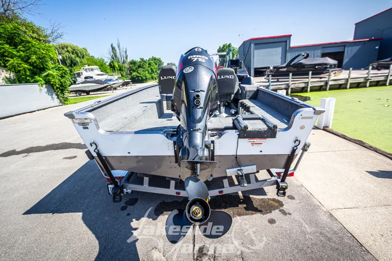 Slide: The Image of 2016 Lund 1675 Impact XS SS boat with Evinrude motor, parked outdoors. - 5