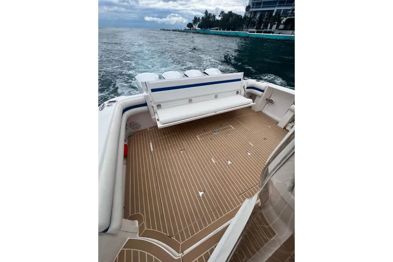 Slide: The Image of 2017 Intrepid 475 Sport Yacht deck with seating, cruising on open water. - 10