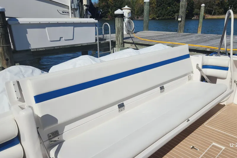 Slide: The Image of 2017 Intrepid 475 Sport Yacht with white seating and blue accents at a dock. - 11