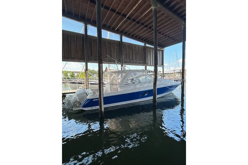 Slide: The Image of 2017 Intrepid 475 Sport Yacht docked under a wooden shelter. - 3