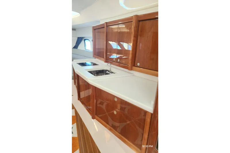 Slide: The Image of Luxurious kitchen area in 2017 Intrepid 475 Sport Yacht with wooden cabinetry and modern sink. - 34
