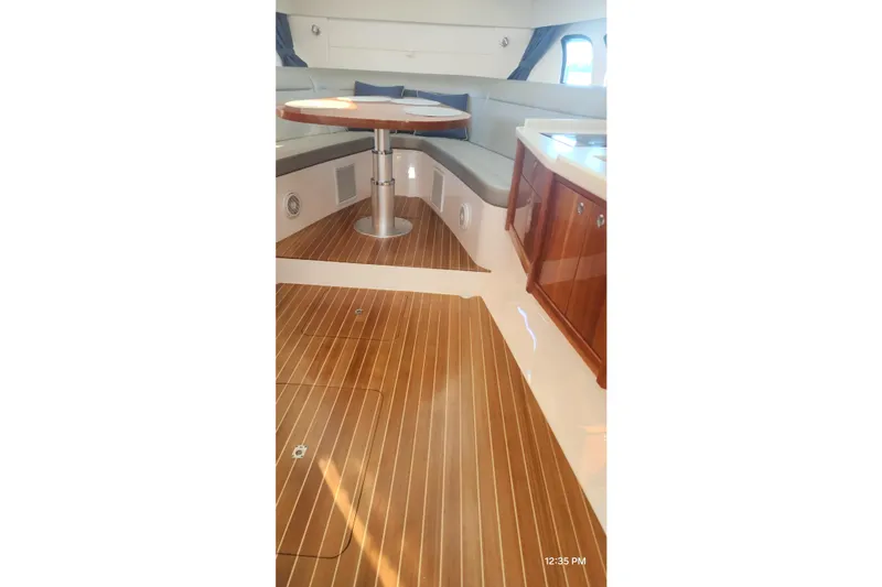 Slide: The Image of Interior of 2017 Intrepid 475 Sport Yacht with wooden flooring and seating area. - 41