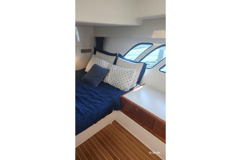 Slide: The Image of Luxurious cabin interior of 2017 Intrepid 475 Sport Yacht with blue bedding and wooden accents. - 43