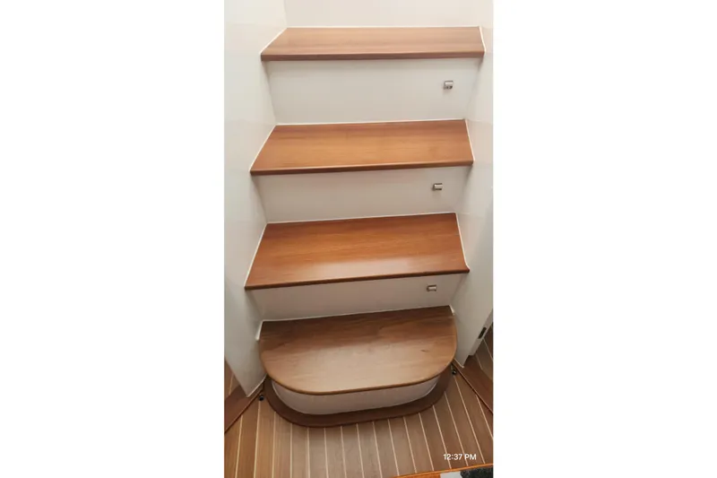 Slide: The Image of Wooden steps inside a 2017 Intrepid 475 Sport Yacht, showcasing elegant interior design. - 44