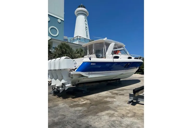 Slide: The Image of 2017 Intrepid 475 Sport Yacht with blue hull, docked near a lighthouse. - 6