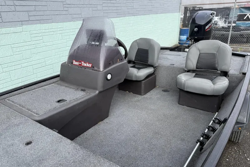 Slide: The Image of 2022 Bass Tracker Classic XL boat interior with two gray seats and steering console. - 7