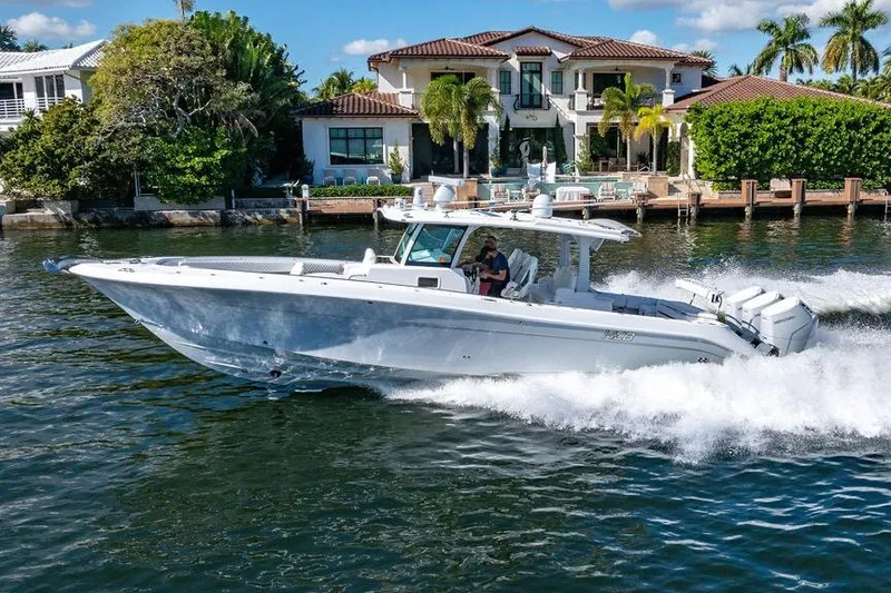 Slide: The Image of 2024 HCB 42 Lujo boat cruising near luxury waterfront home. - 10