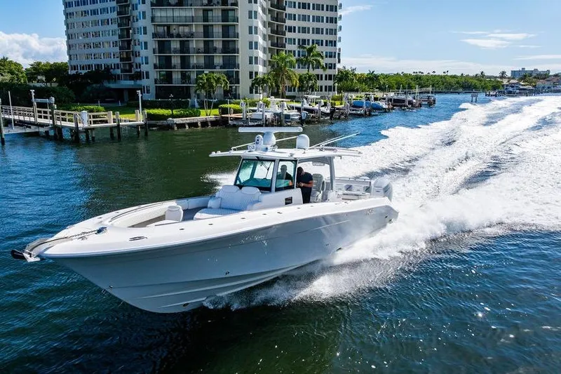 Slide: The Image of 2024 HCB 42 Lujo boat cruising on water near waterfront buildings. - 16