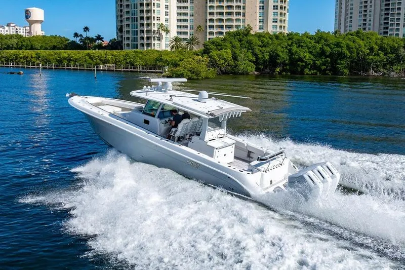 Slide: The Image of 2024 HCB 42 Lujo boat cruising on water near waterfront buildings. - 18