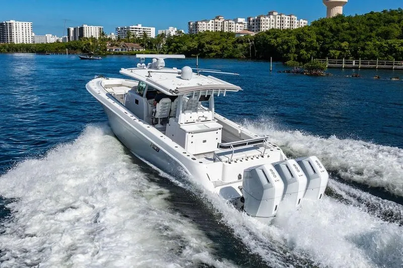 Slide: The Image of 2024 HCB 42 Lujo boat cruising on a scenic waterway with city skyline. - 20