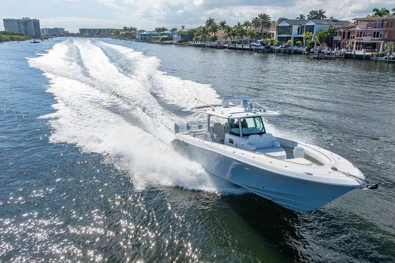 Slide: The Image of 2024 HCB 42 Lujo boat cruising on a sunny waterway, leaving a wake behind. - 23