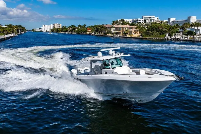Slide: The Image of 2024 HCB 42 Lujo cruising on a scenic waterway with luxury homes in the background. - 29