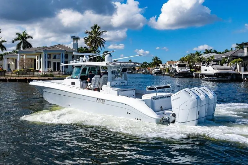 Slide: The Image of 2024 HCB 42 Lujo boat cruising in a scenic waterfront setting with palm trees. - 4