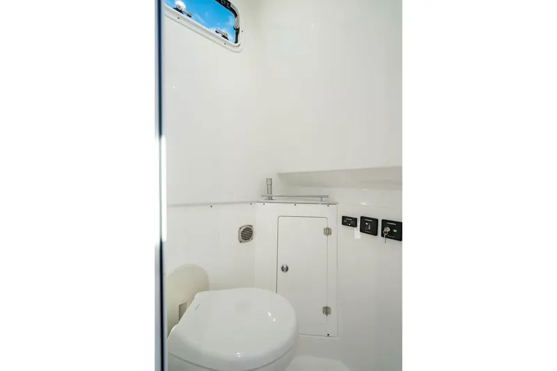 Slide: The Image of 2024 HCB 42 Lujo boat interior bathroom with white fixtures and small window. - 43