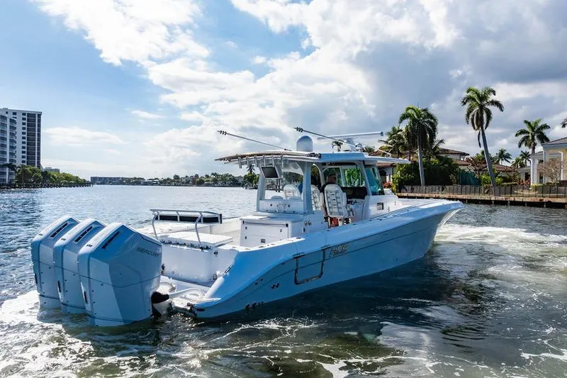 Slide: The Image of 2024 HCB 42 Lujo boat cruising on a sunny waterway with palm trees. - 5