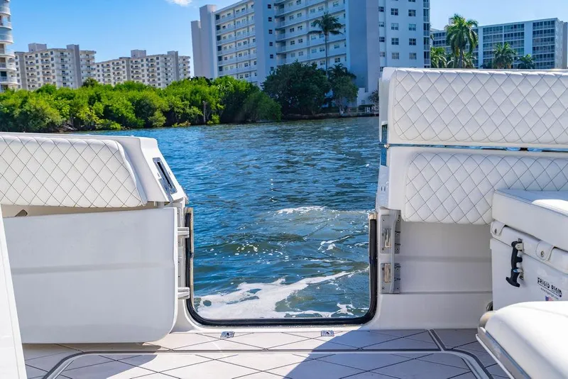 Slide: The Image of 2024 HCB 42 Lujo boat with open deck, overlooking water and cityscape. - 50