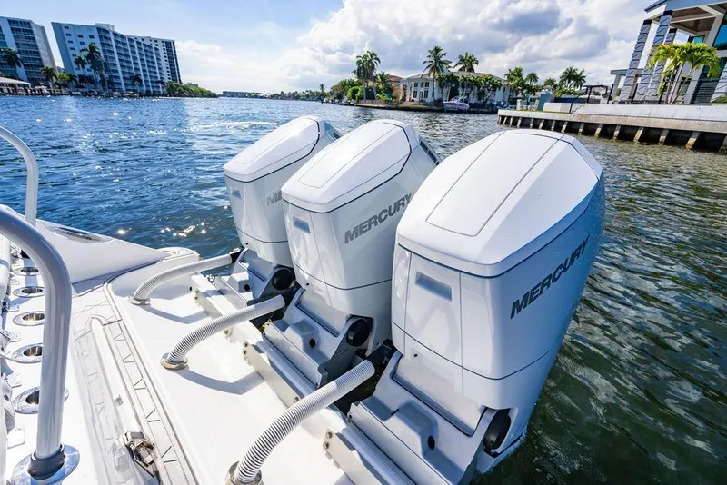 Slide: The Image of 2024 HCB 42 Lujo boat with triple Mercury outboard engines on a sunny waterfront. - 51