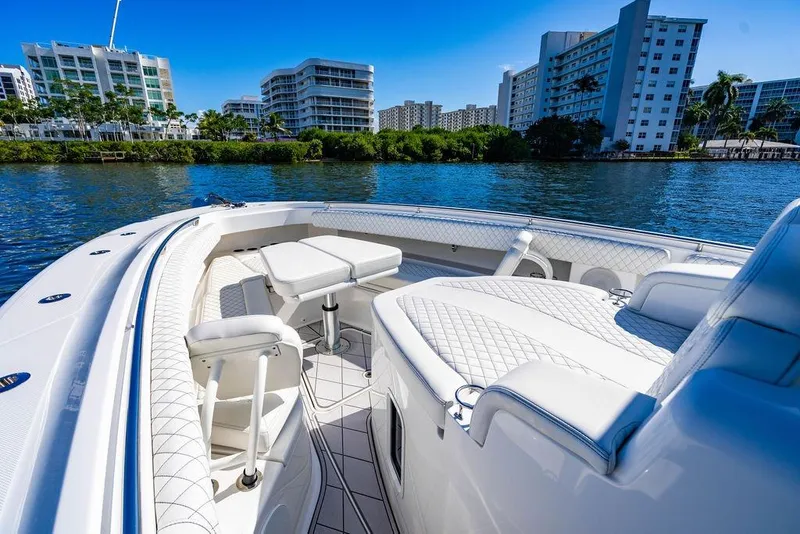 Slide: The Image of 2024 HCB 42 Lujo boat with luxurious seating, cruising near waterfront buildings. - 59