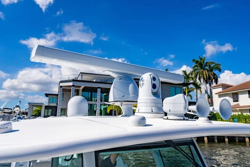 Slide: The Image of 2024 HCB 42 Lujo boat with advanced radar and navigation equipment, docked near luxury homes. - 62