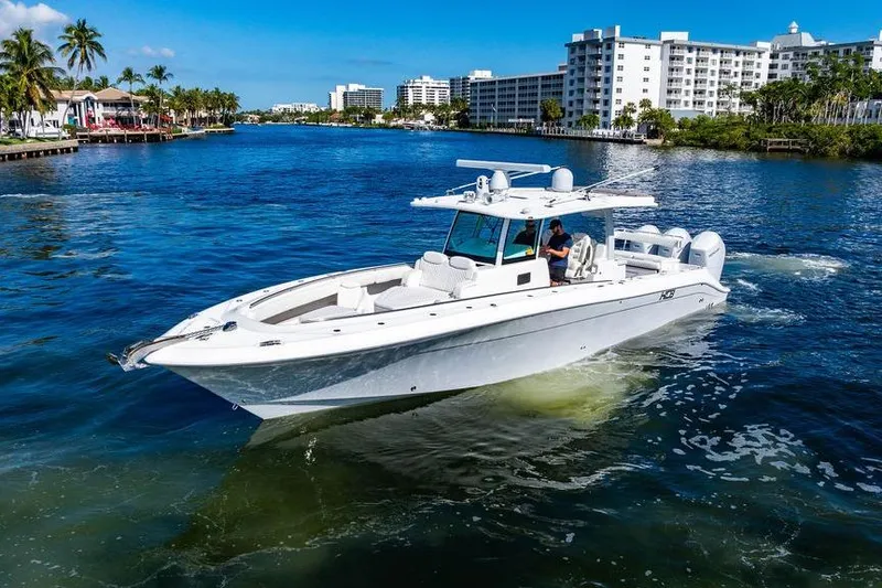 Slide: The Image of 2024 HCB 42 Lujo boat cruising in a scenic waterfront setting with modern buildings. - 7