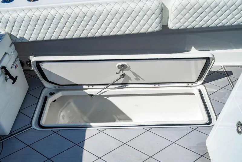 Slide: The Image of 2024 HCB 42 Lujo boat storage compartment with quilted seating and open hatch. - 73