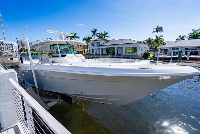 Slide: The Image of 2024 HCB 42 Lujo boat docked by waterfront homes under clear blue sky. - 76