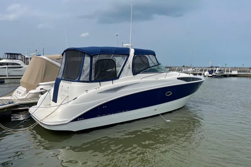 The Image of 2007 Bayliner 325 boat docked in marina, featuring blue and white exterior. - 0