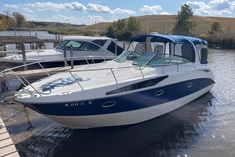 Slide: The Image of 2007 Bayliner 325 boat docked on a sunny day with blue canopy. - 1
