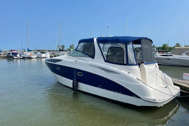 Slide: The Image of 2007 Bayliner 325 boat docked in a marina under clear blue skies. - 2