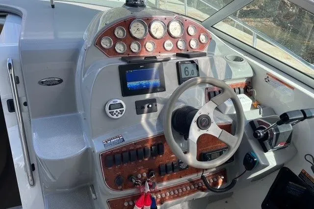 Slide: The Image of 2007 Bayliner 325 boat dashboard with steering wheel, gauges, and navigation controls. - 6