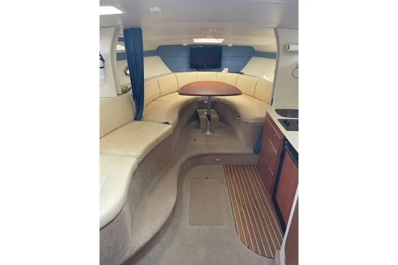 Slide: The Image of Interior of a 2007 Bayliner 325 boat with seating, table, and kitchenette. - 7