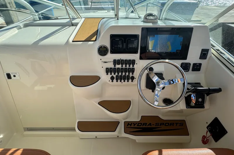 Slide: The Image of 2011 Hydra-Sports 3000 VX boat dashboard with steering wheel and navigation controls. - 24