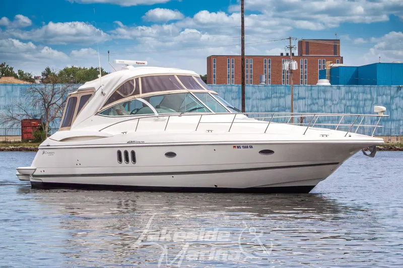 Slide: The Image of 2006 Cruisers Yachts 420 Express on water, urban backdrop, partly cloudy sky. - 10