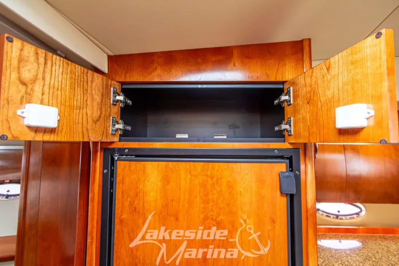 Slide: The Image of Open wooden cabinet in 2006 Cruisers Yachts 420 Express interior, Lakeside Marina logo visible. - 100