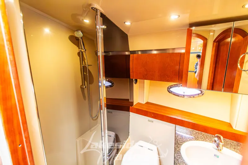Slide: The Image of Luxurious bathroom in 2006 Cruisers Yachts 420 Express with modern fixtures and wood accents. - 104