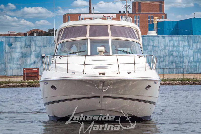 Slide: The Image of 2006 Cruisers Yachts 420 Express on water, front view, urban backdrop. - 11