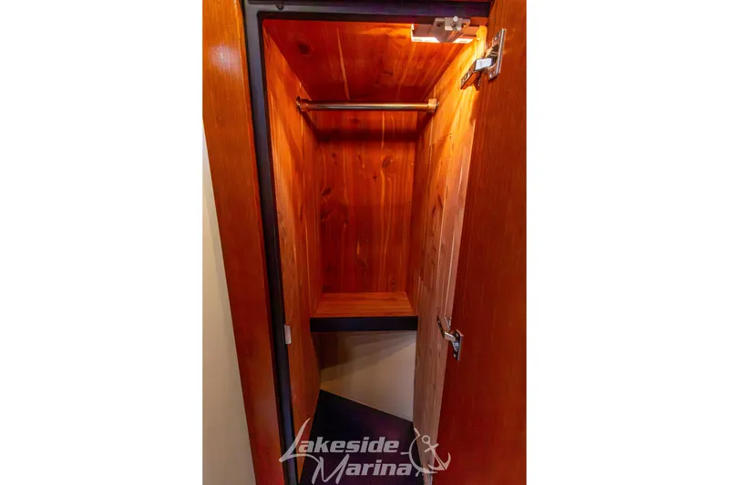 Slide: The Image of Wooden closet interior on 2006 Cruisers Yachts 420 Express, featuring hanging rod and shelf. - 116