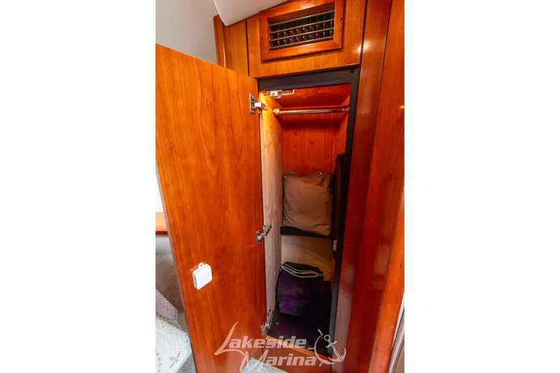 Slide: The Image of Wooden closet interior on 2006 Cruisers Yachts 420 Express, featuring pillows and storage space. - 117