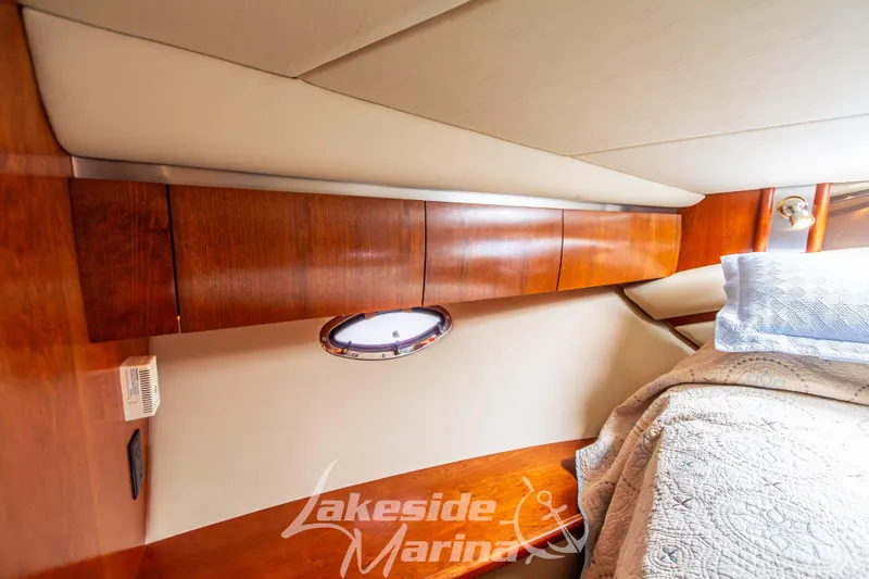 Slide: The Image of Interior cabin of 2006 Cruisers Yachts 420 Express with wood cabinetry and bedding. - 120