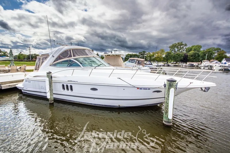 Slide: The Image of 2006 Cruisers Yachts 420 Express docked at marina under cloudy sky. - 13