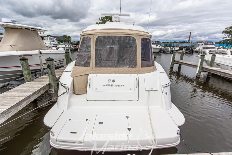 Slide: The Image of 2006 Cruisers Yachts 420 Express docked at marina, rear view with covered cockpit. - 17