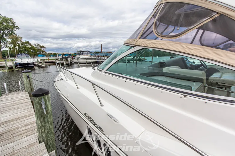 Slide: The Image of 2006 Cruisers Yachts 420 Express docked at marina, showcasing sleek design and spacious deck. - 20
