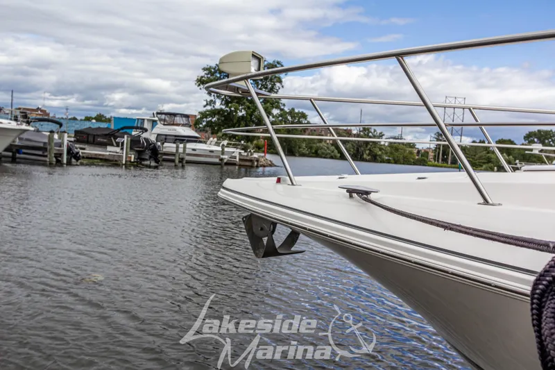 Slide: The Image of 2006 Cruisers Yachts 420 Express docked at Lakeside Marina, calm waters, cloudy sky. - 21